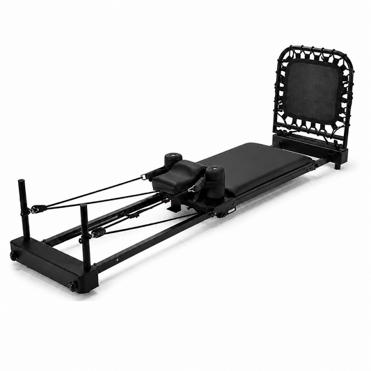 A black Pilates reformer machine with an attached bungee trampoline backrest, featuring padded foam surfaces and resistance cords, photographed on a clean white background.